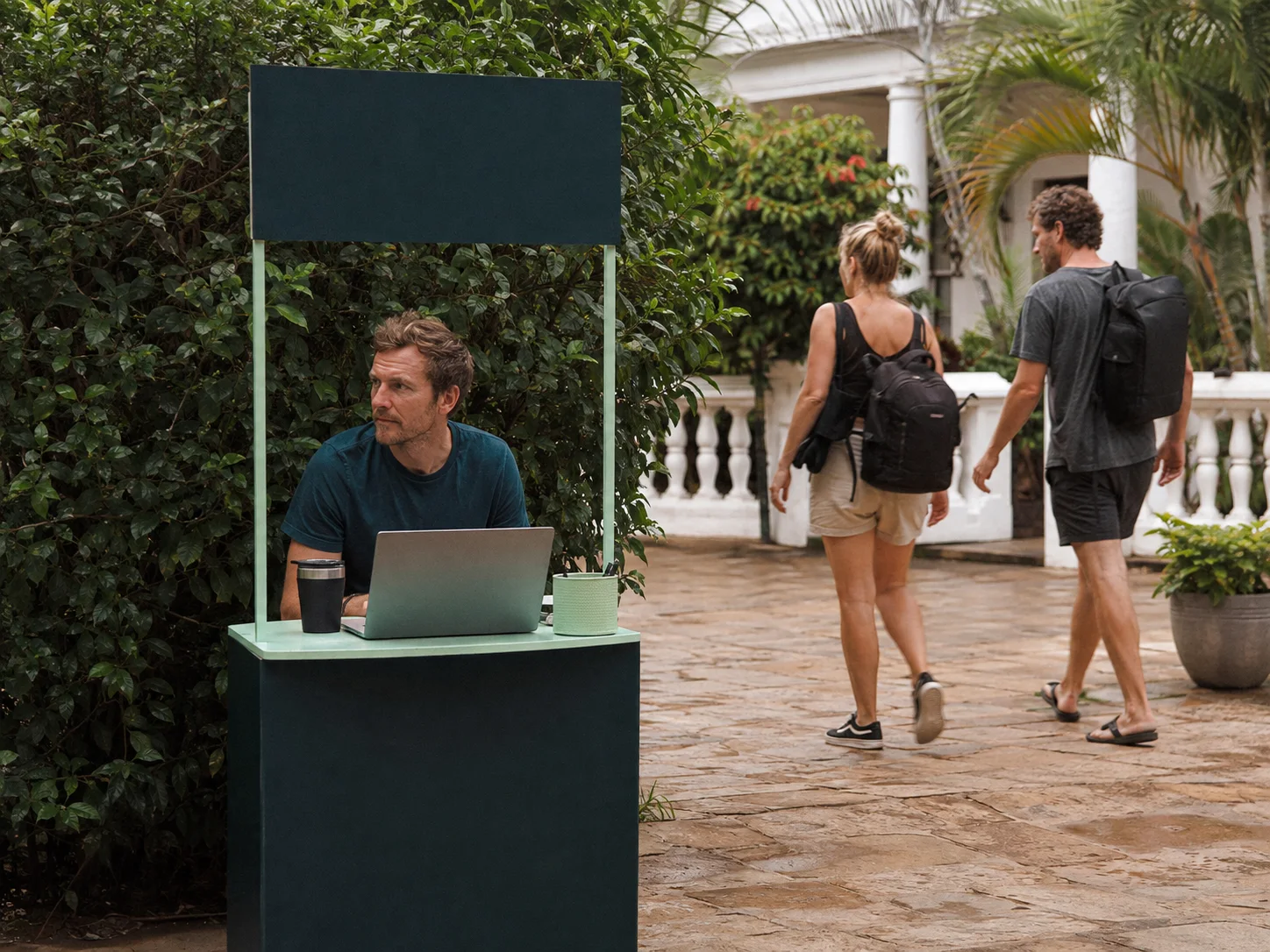 A founder waits at a launch booth that faces the wrong way while potential customers walk past